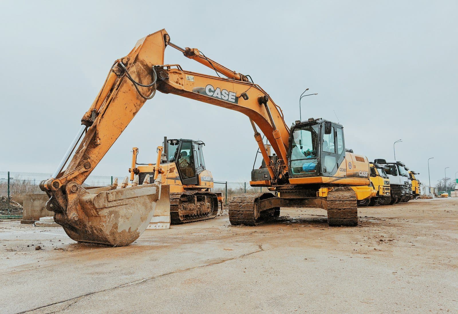 Excavators and support plant staged in a line across an equipment yard